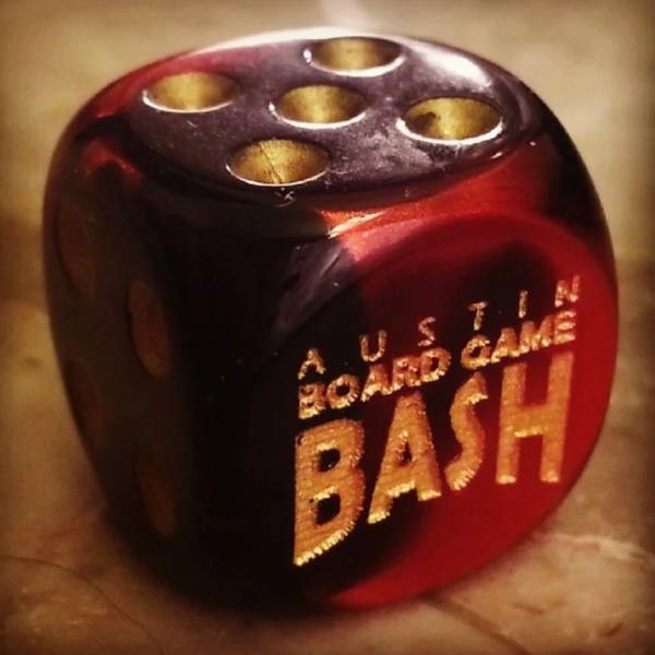 The first custom Board Game Bash die from 2011, oxblood red with gold engraving